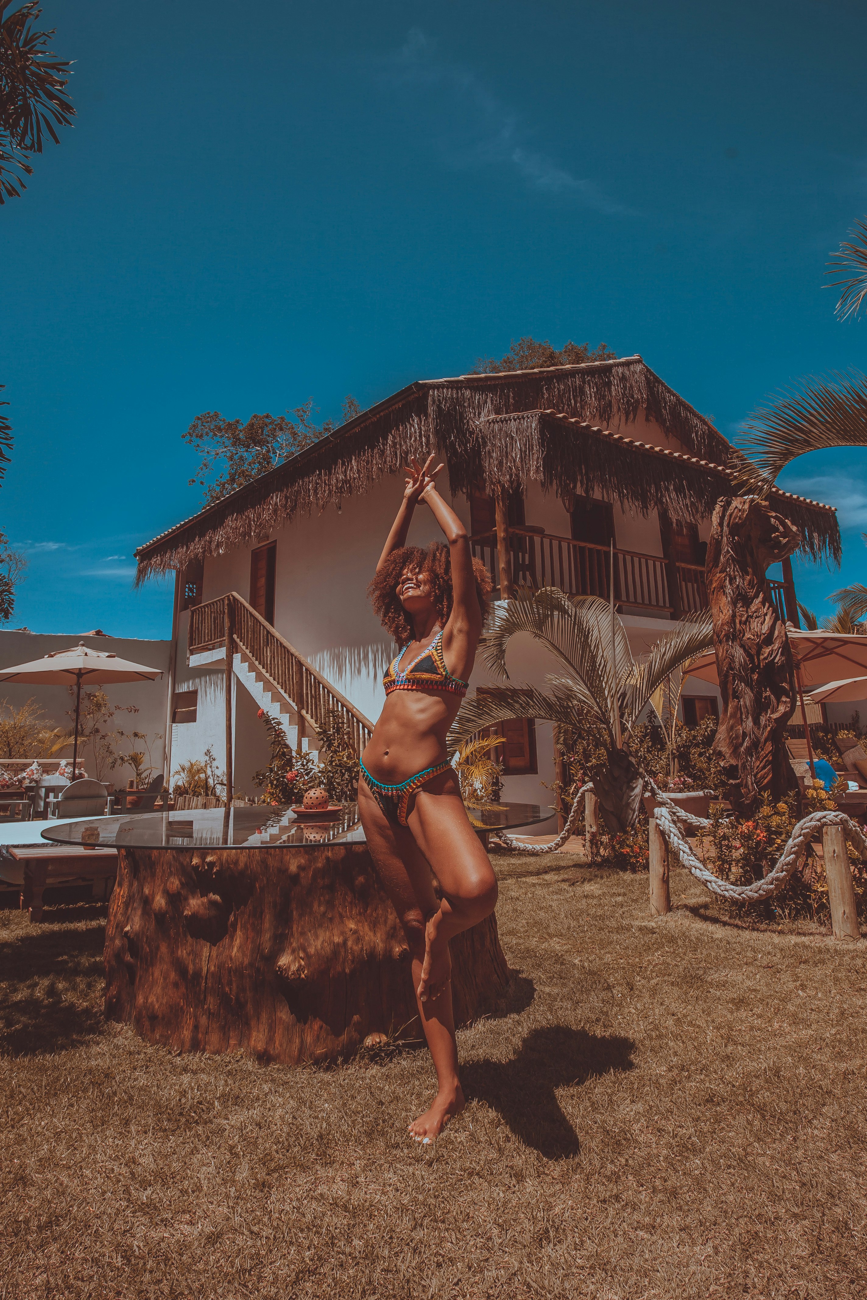 woman in black bikini standing on brown sand during daytime